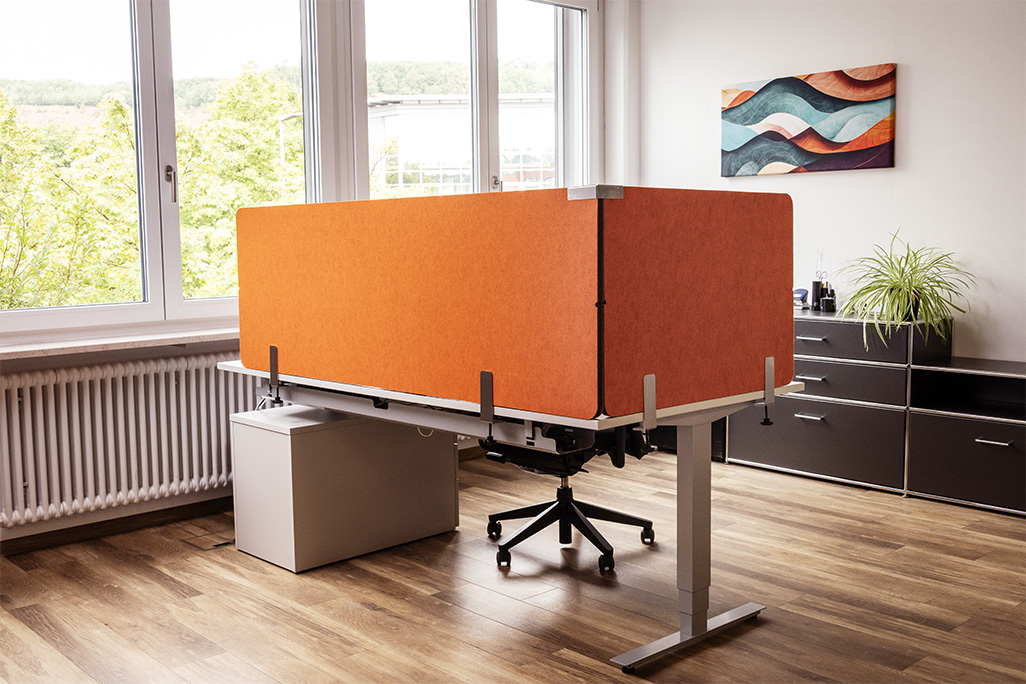 Orangene Tischtrennwand in einem Büro auf dem Schreibtisch montiert