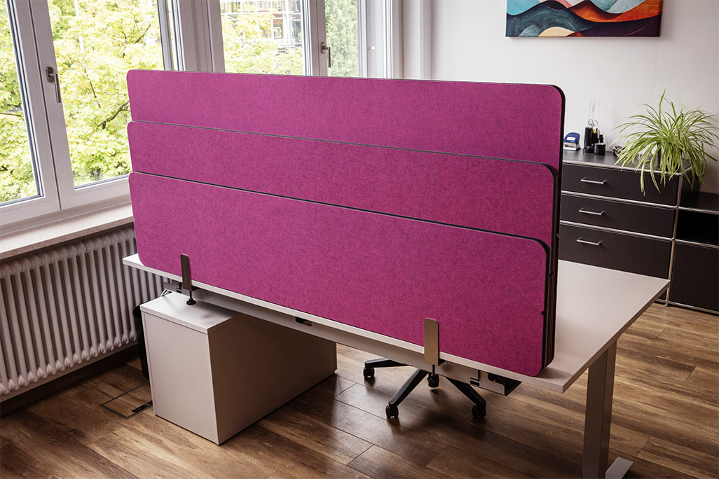 Pinke Tischtrennwand in einem Büro auf dem Schreibtisch montiert
