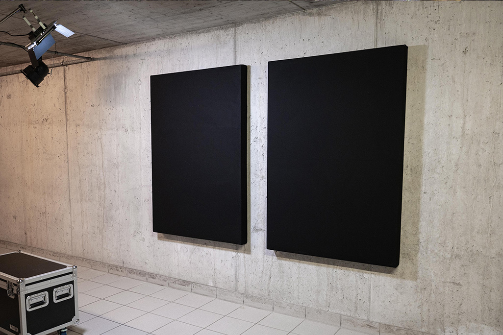 2 schwarze Schallabsorber an einer Betonwand
