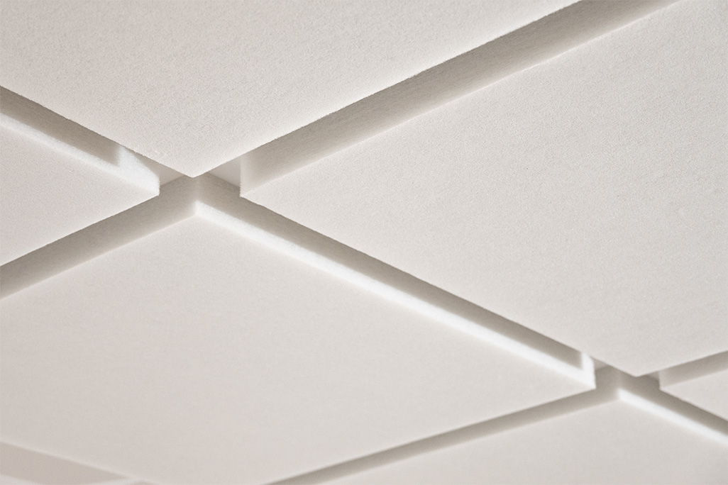 Decke mit einem 3x3 Muster aus quadratischen weißen Vliesabsorbern