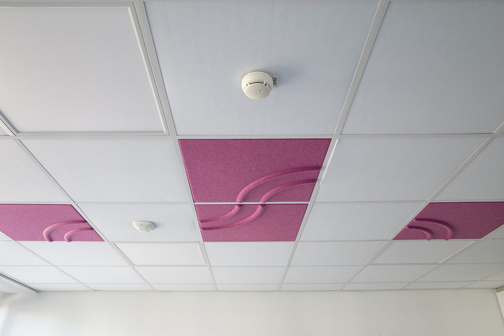 Découpe d'un plafond modulaire du commerce avec absorbeurs acoustiques soni COMFORT SD en blanc et soni COLOR Design insérés