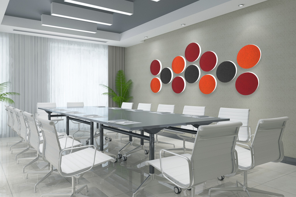 12 farbige Schallabsorber in Form eines Kreises (soni ELEMENT CIRCLE) an einer Wand in einem modernen Besprechungszimmer mit großem Tisch und 12 weißen Stühlen angebracht.