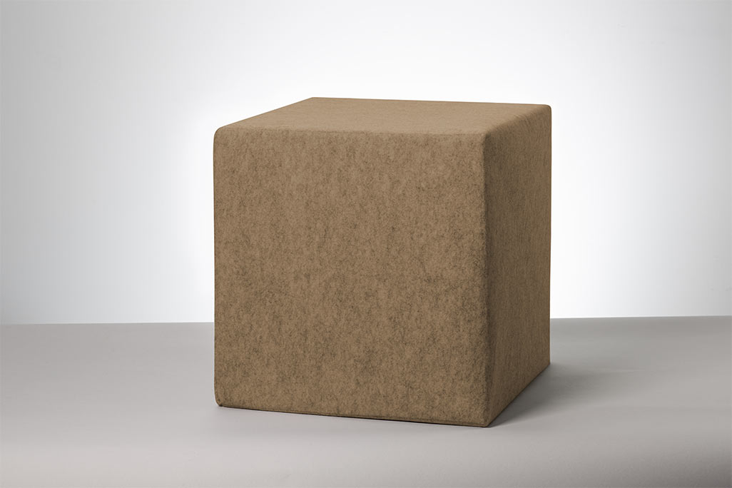 Cube de siège beige photographié sur fond blanc.