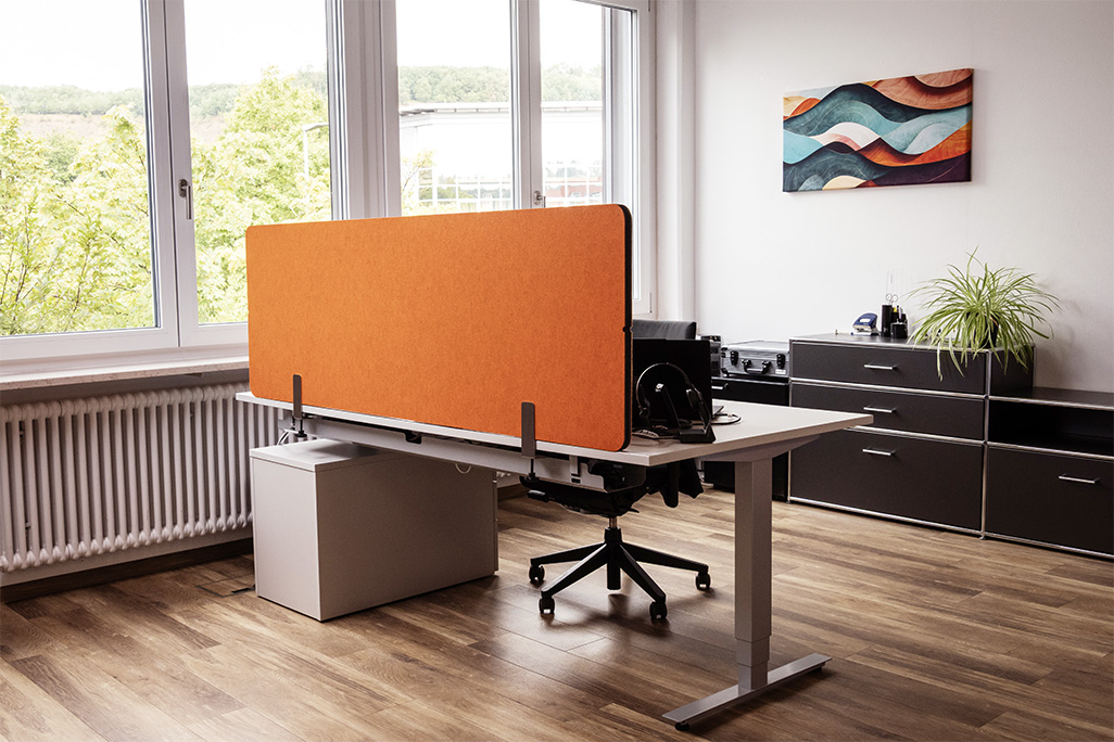 Orangene Tischtrennwand in einem Büro auf dem Schreibtisch montiert